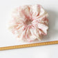 Gifty scrunchie worn on wrist displaying colorful printed fabric