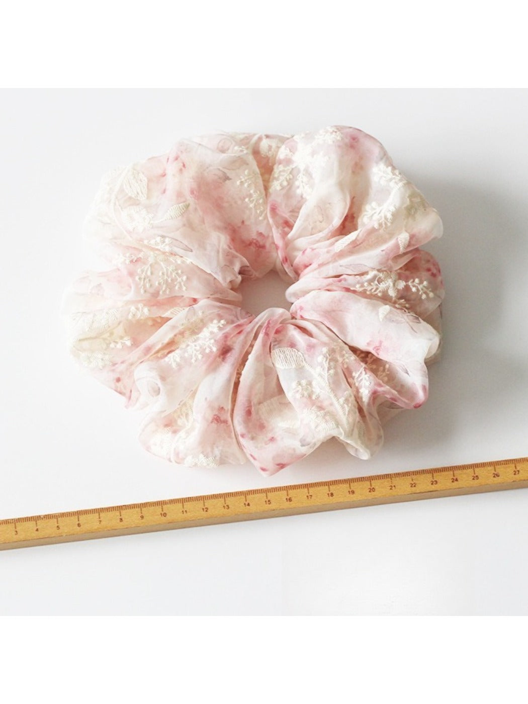 Gifty scrunchie worn on wrist displaying colorful printed fabric