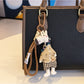Giraffe charm keychain with a shiny gold finish on a dark surface