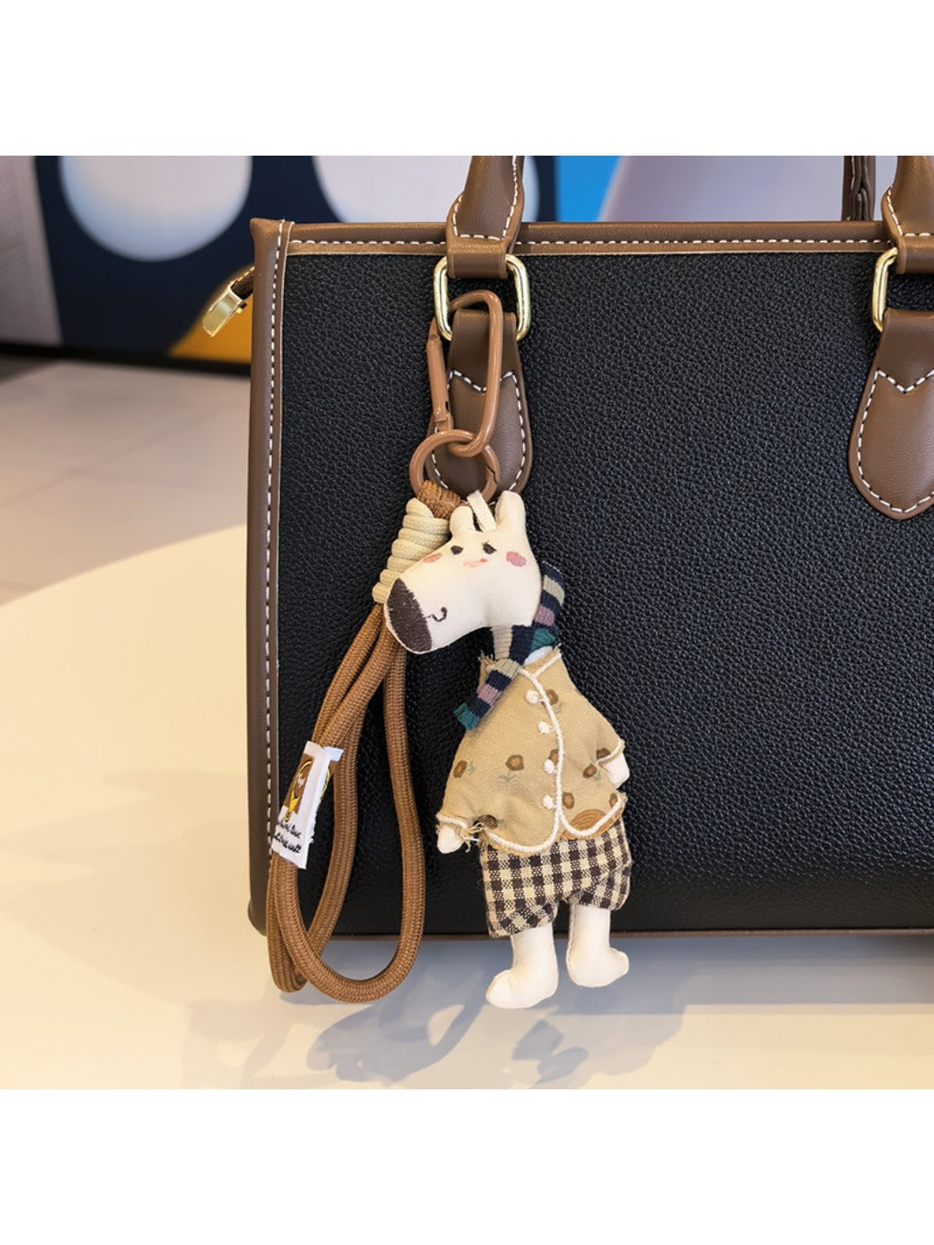 Giraffe charm keychain with a shiny gold finish on a dark surface