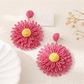 Detailed shot of colorful raffia strands forming floral pattern on earrings