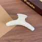 Beau acetate curved claw clip held in hand, showing size and shape