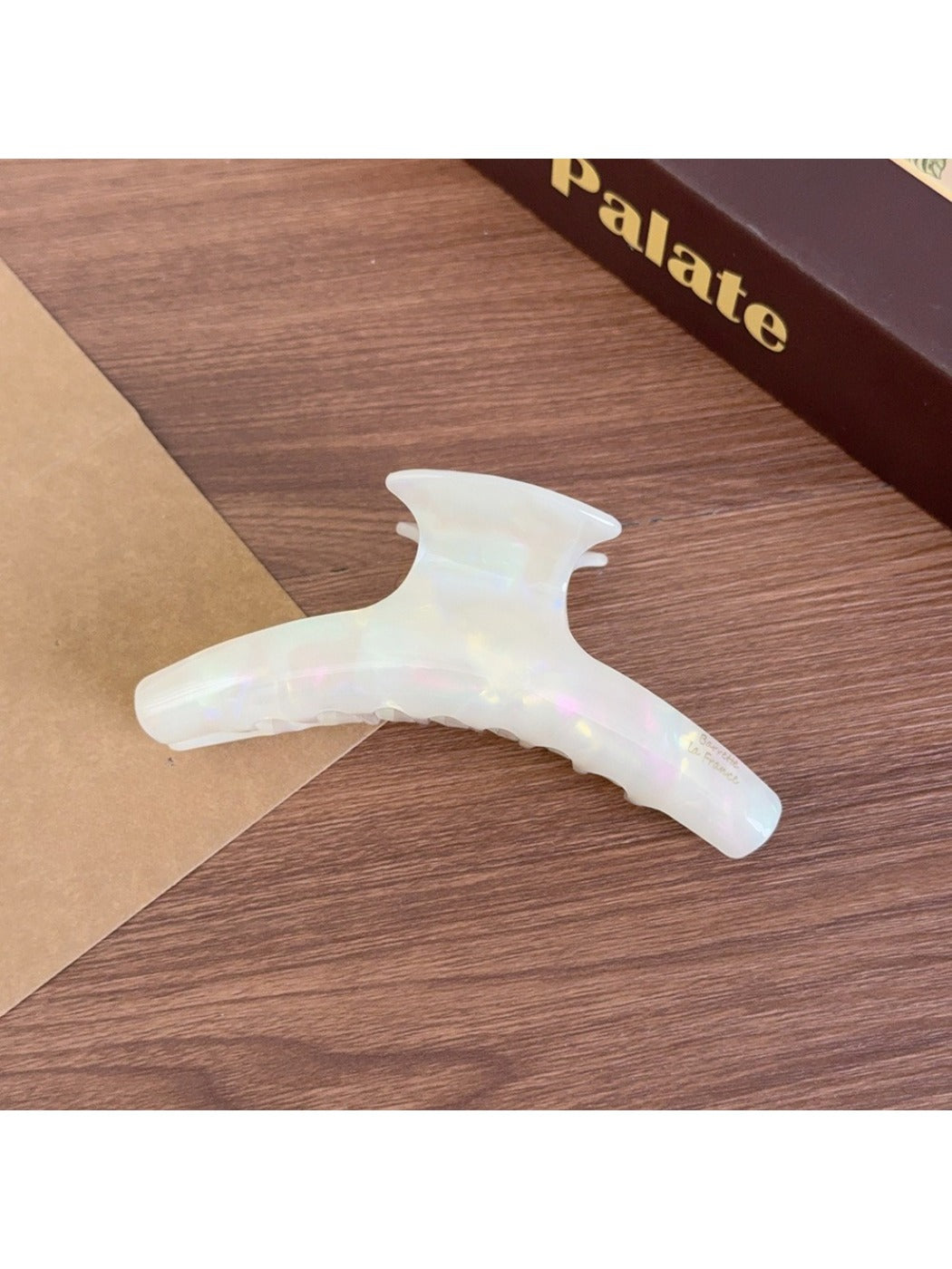 Beau acetate curved claw clip held in hand, showing size and shape
