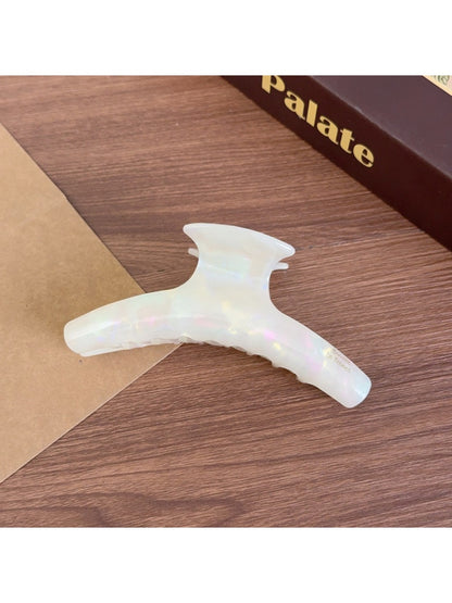 Beau acetate curved claw clip held in hand, showing size and shape