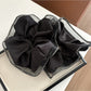 Gifty chic minimalist aesthetic scrunchie in soft beige fabric on white background