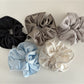 Close-up of Gifty satin finish silky scrunchie in soft pink fabric