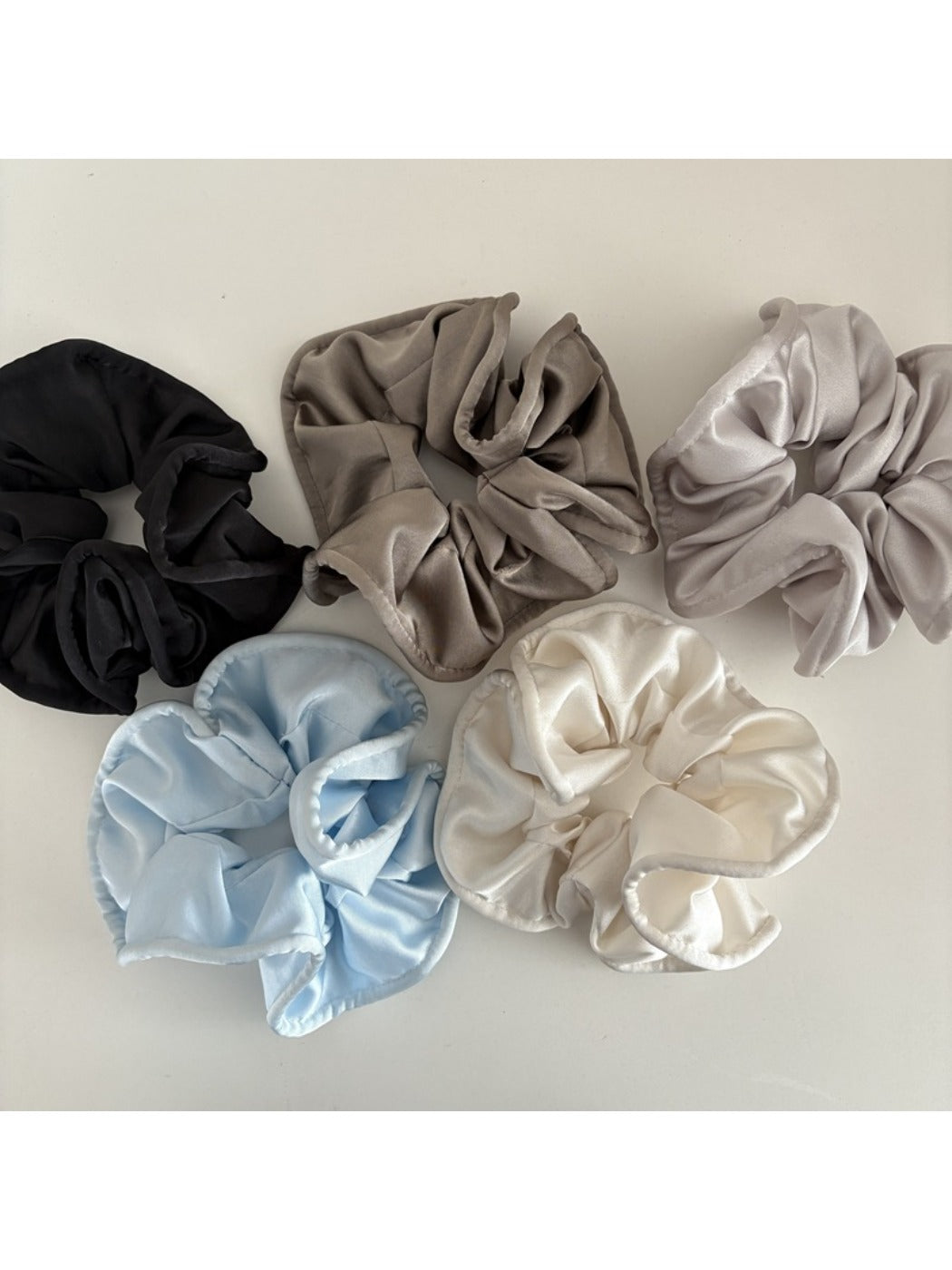 Close-up of Gifty satin finish silky scrunchie in soft pink fabric