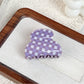 Purple plaid hair claw clip placed on wooden surface