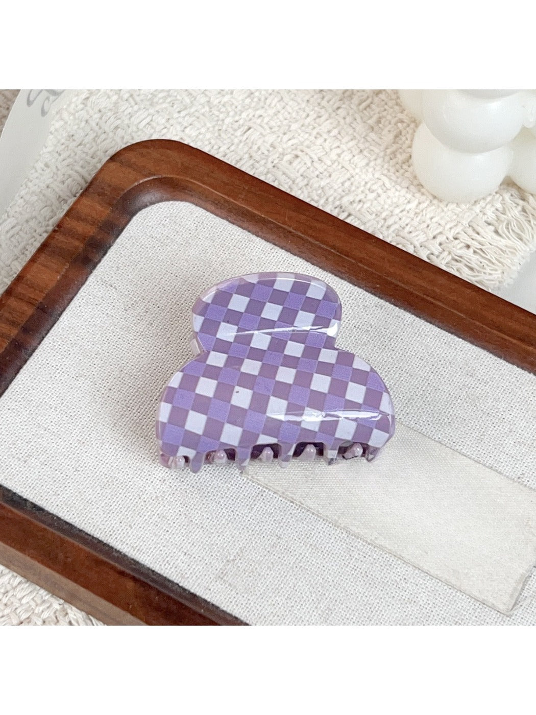 Purple plaid hair claw clip placed on wooden surface