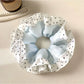 Close-up of Gifty scrunchie showing smooth fabric texture and polka dot pattern