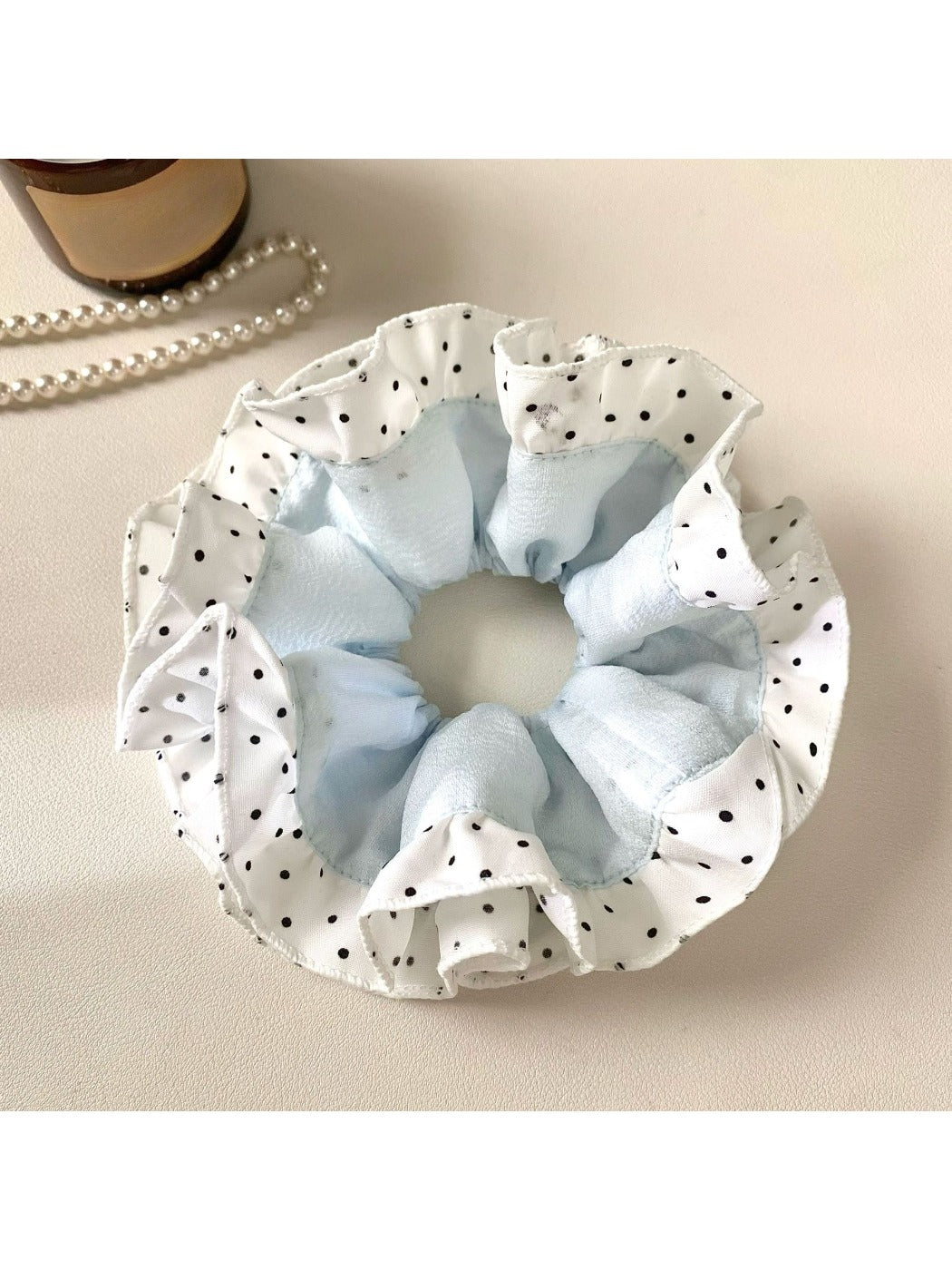 Close-up of Gifty scrunchie showing smooth fabric texture and polka dot pattern