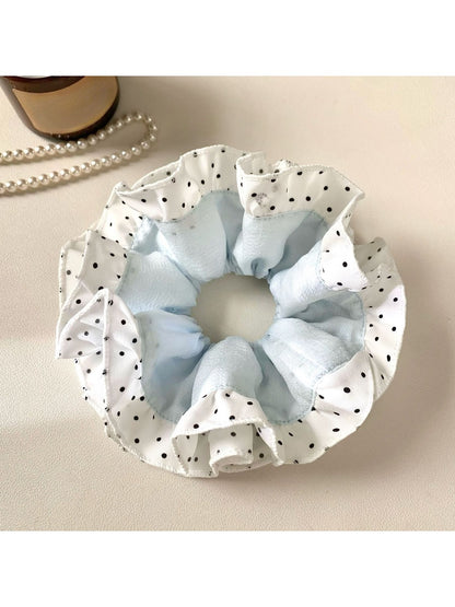 Close-up of Gifty scrunchie showing smooth fabric texture and polka dot pattern
