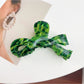 Beau delicate bow hair claw clip held between fingers showing size
