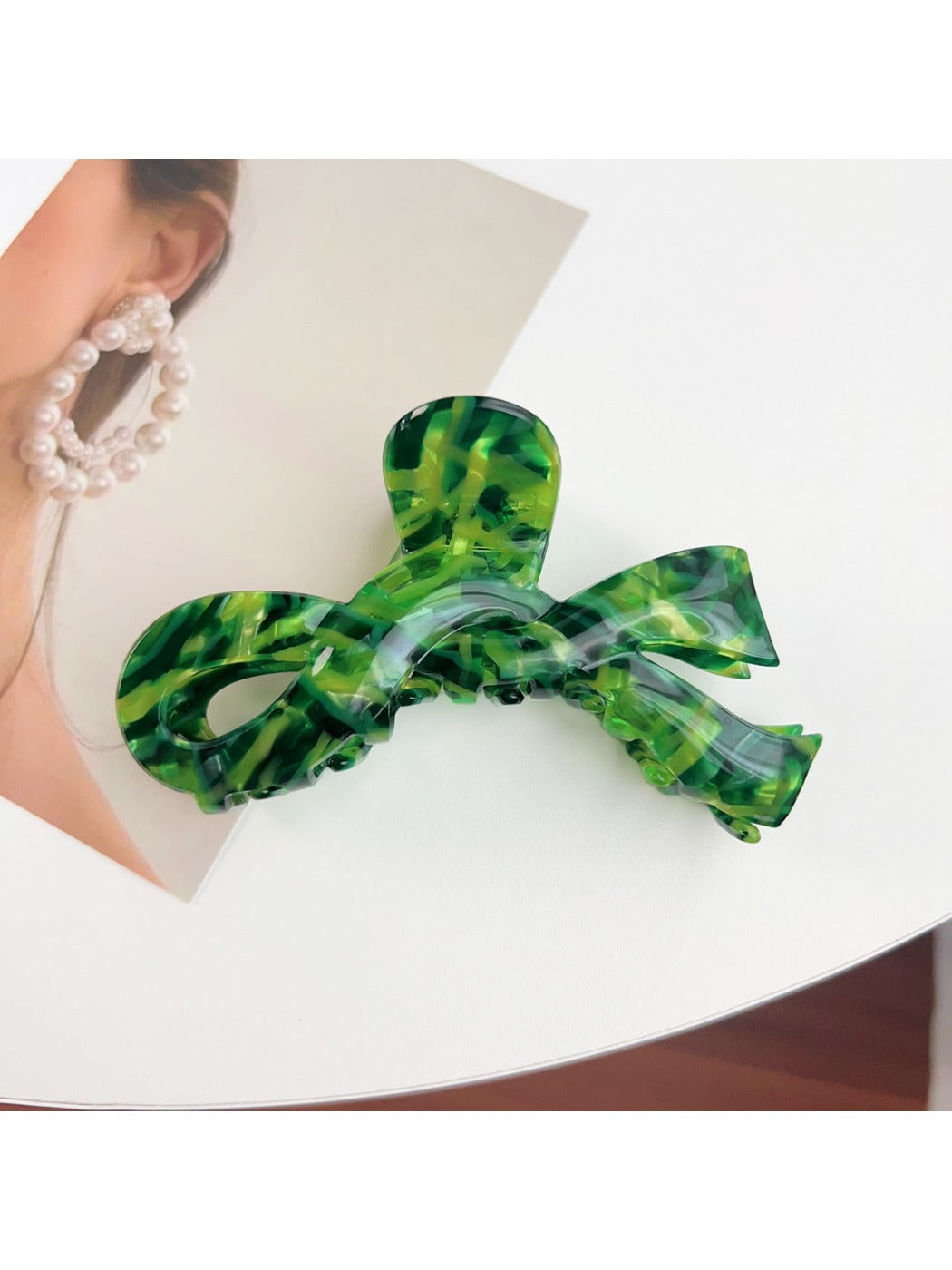 Beau delicate bow hair claw clip held between fingers showing size