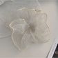 Flat lay of Gifty pleated scrunchie on a white background highlighting its elegant design