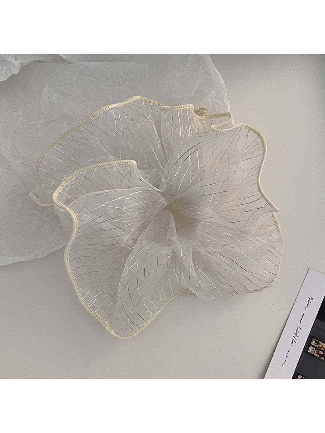 Flat lay of Gifty pleated scrunchie on a white background highlighting its elegant design