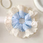 Gifty minimalist scrunchie styled on a wrist with white fabric and black polka dots
