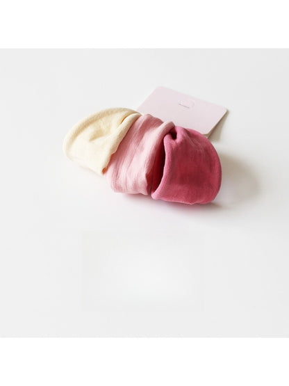 Individual hair tie laid flat to show thickness and fabric detail