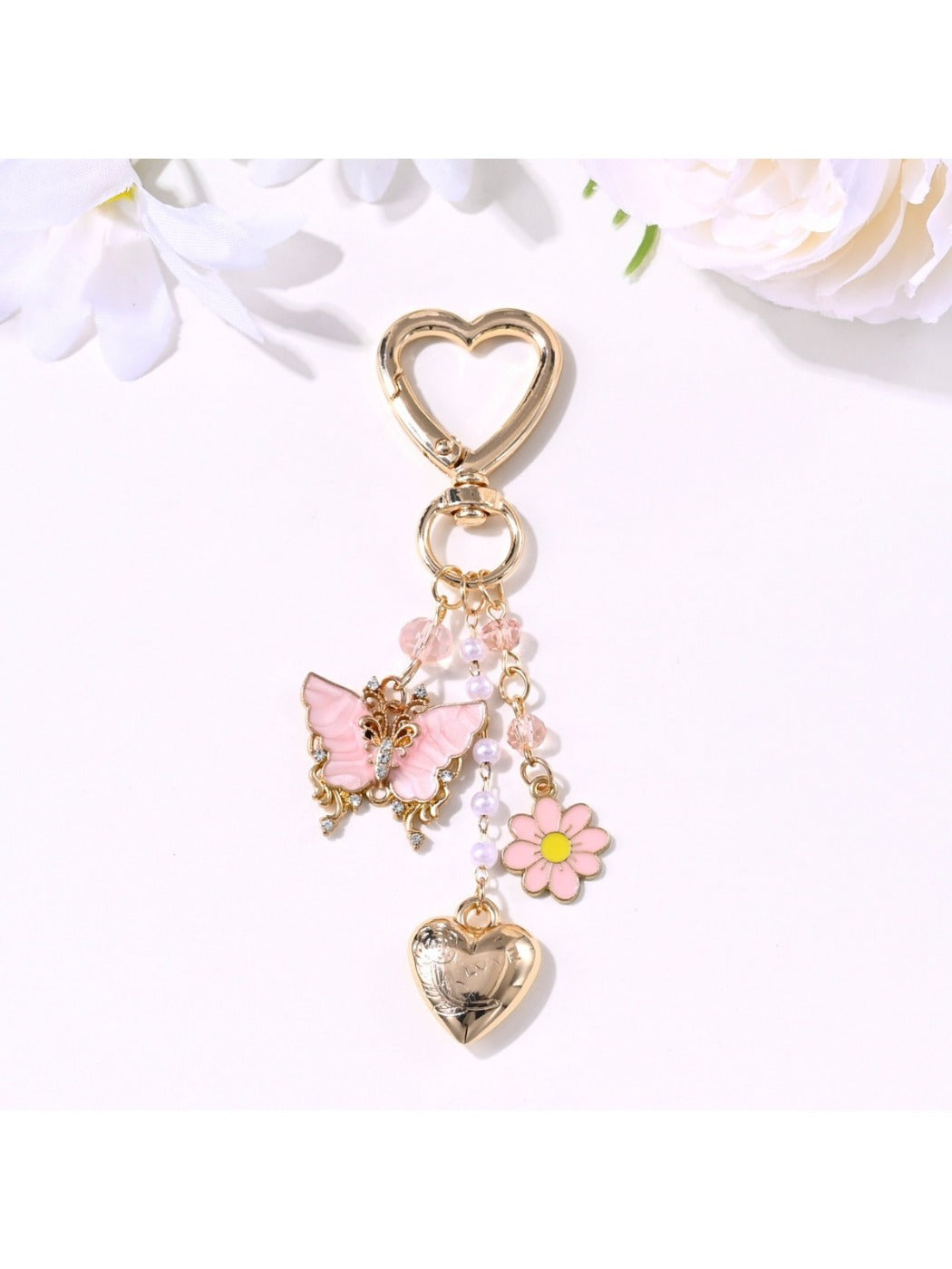 Butterfly heart keychain attached to a set of keys on a wooden surface