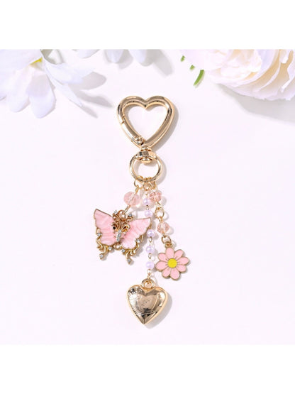 Butterfly heart keychain attached to a set of keys on a wooden surface