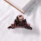 Beau acetate bow shaped claw clip on fabric background for texture contrast