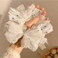 Close-up of Gifty scrunchie showing lace bow detail and floral pattern
