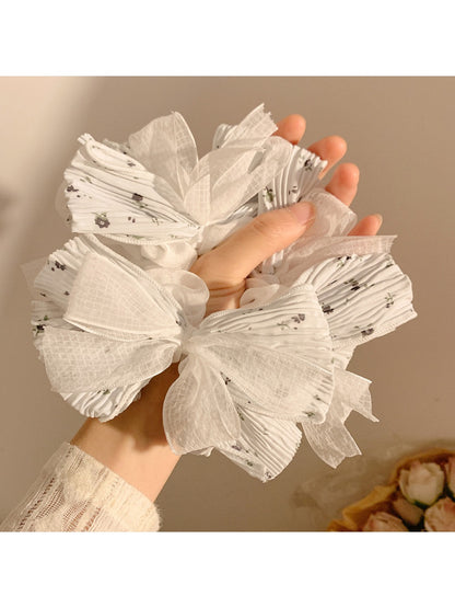 Close-up of Gifty scrunchie showing lace bow detail and floral pattern