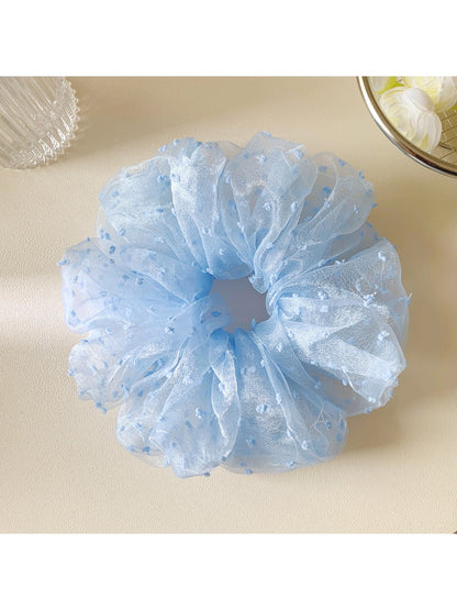 Gifty polka dot scrunchie styled on a wrist as a fashion accessory