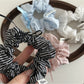 Side view of Gifty Sweet Bow Stripe Scrunchie highlighting fabric texture and bow shape