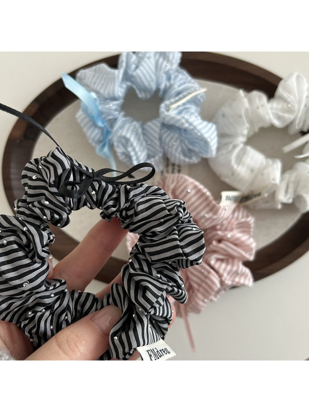 Side view of Gifty Sweet Bow Stripe Scrunchie highlighting fabric texture and bow shape