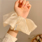 Gifty shiny scrunchie styled on a model's wrist with casual outfit