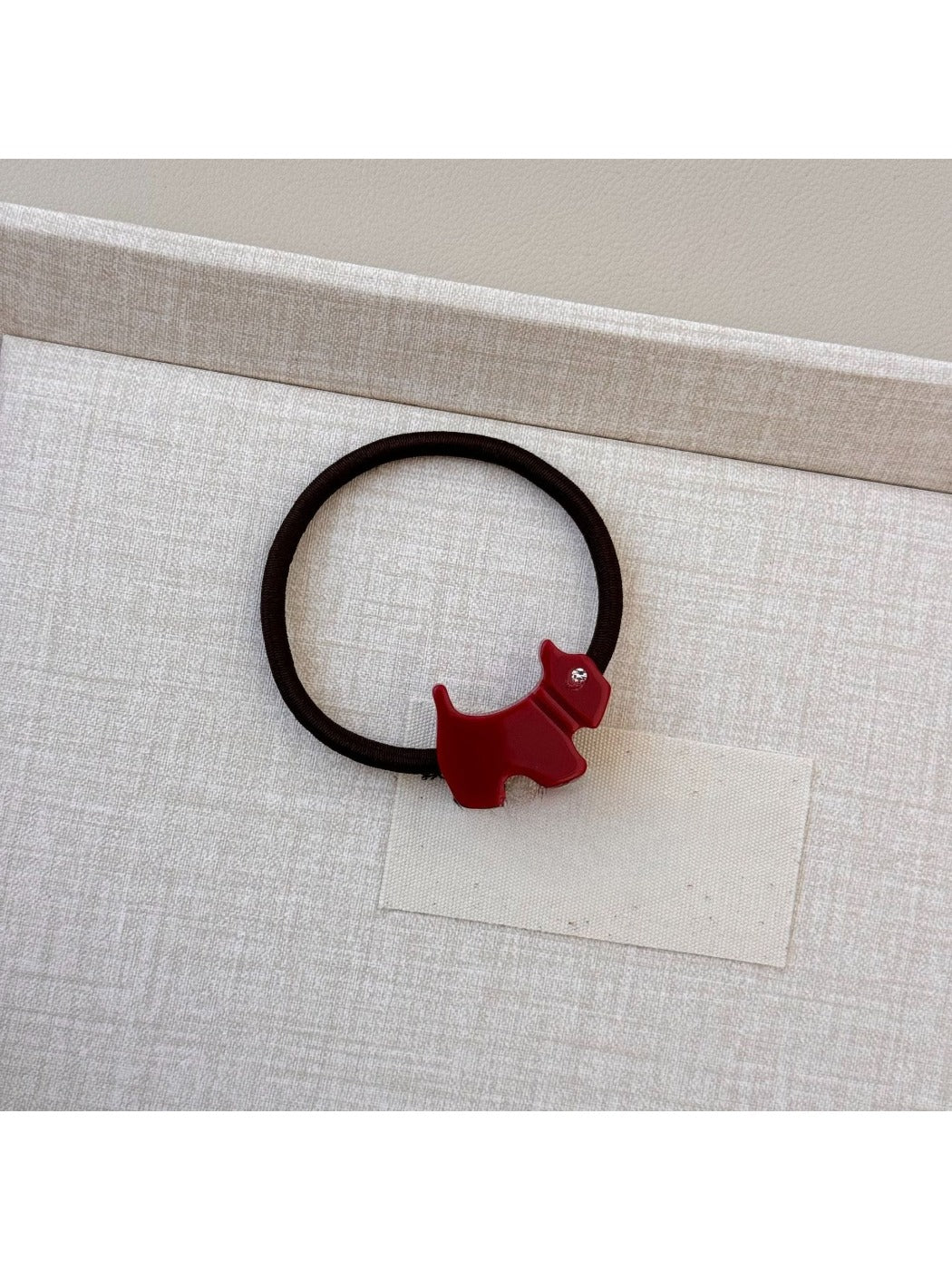 Gifty cartoon puppy hair tie stretched to show elasticity and charm details