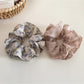 Side view of Gifty vintage floral print scrunchie highlighting ruffled texture