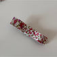Beau pink floral hair clip next to pink flowers for color comparison