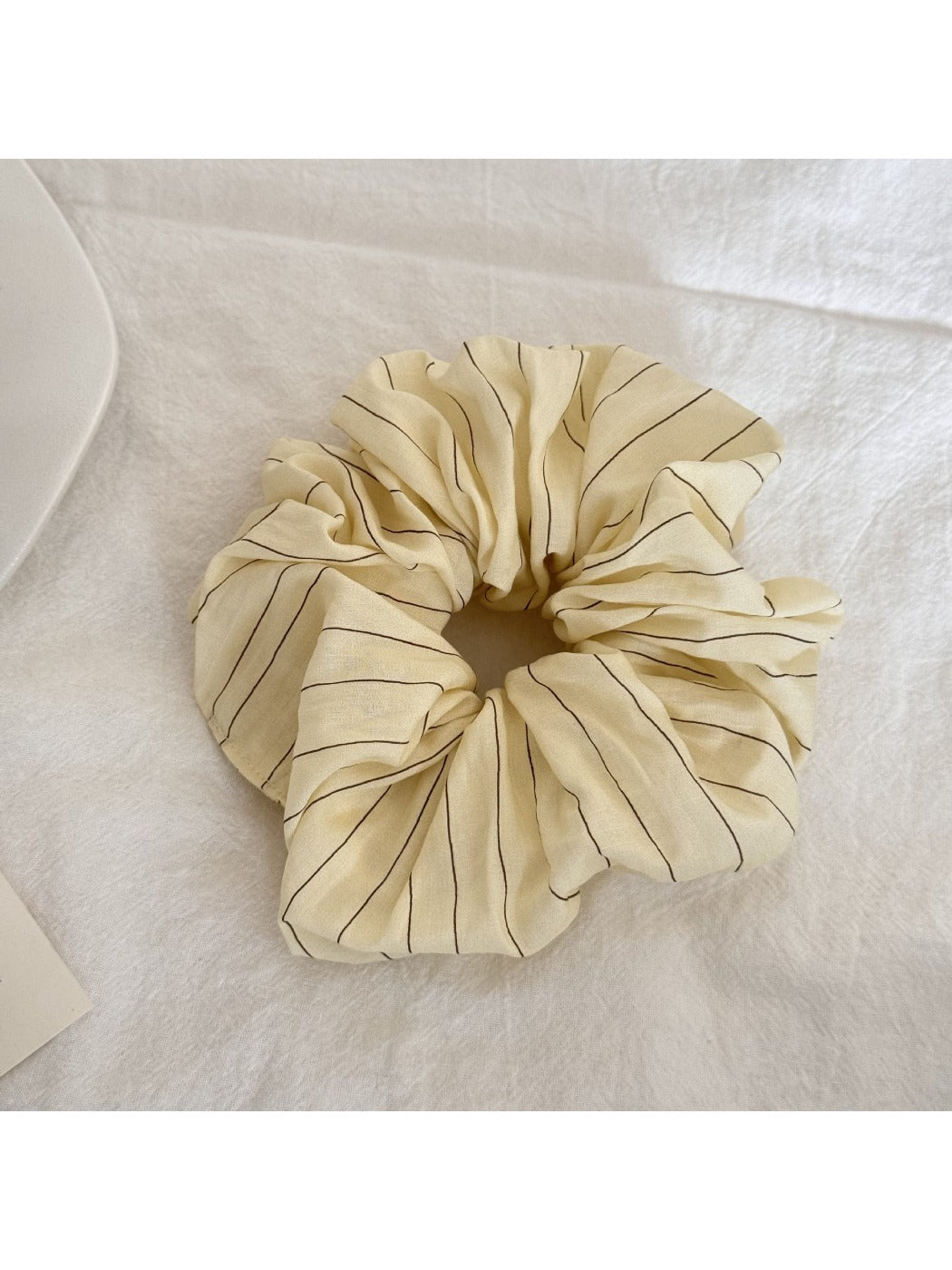 Yellow striped scrunchie displayed flat showing full pattern and shape