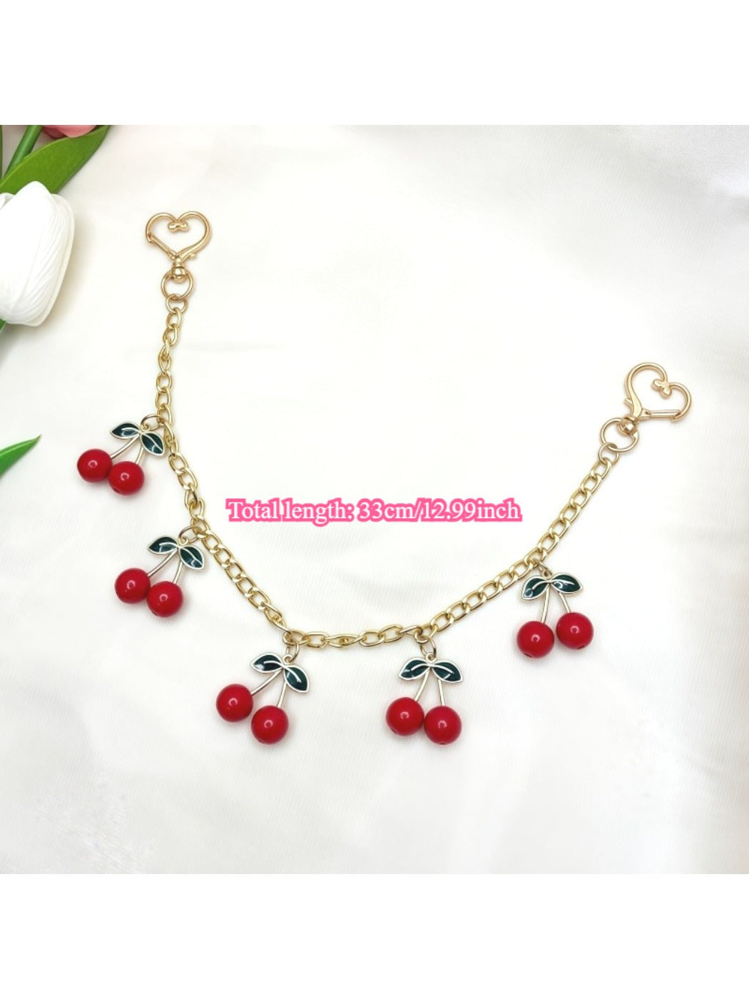 Top view of the cherry charm with silver keyring and green leaf accent