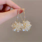 Model wearing Earedge Hydrangea shaped drop earrings showcasing length and style