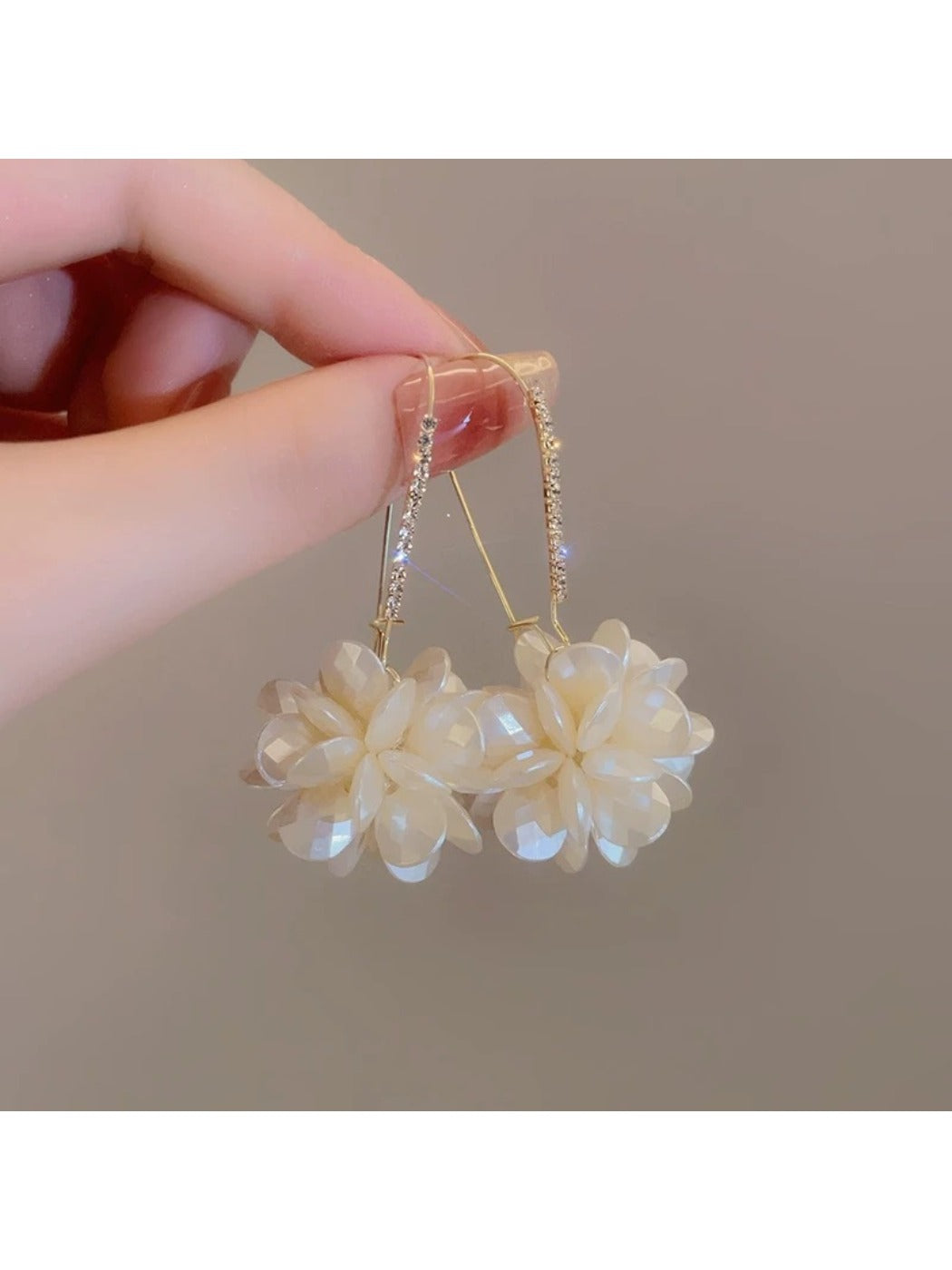 Model wearing Earedge Hydrangea shaped drop earrings showcasing length and style