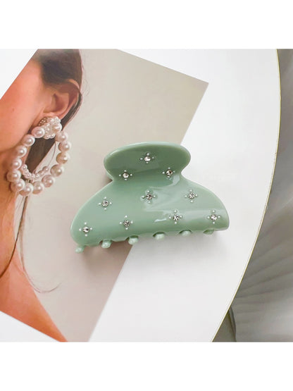 Beau hair claw clip displayed on a wooden surface with natural lighting