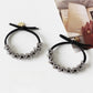 Gifty hair tie stretched to show elasticity and bead details on a white background