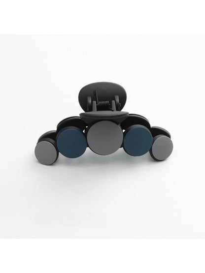 Beau hair clip resting on a wooden table with soft shadows