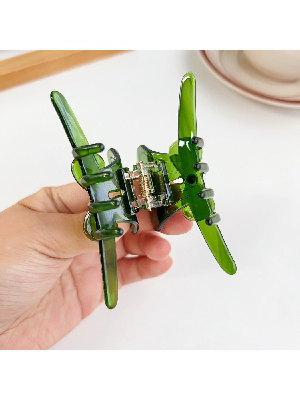 Beau hair claw clip open, displaying spring mechanism and bow accent