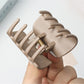 Beau half circle hair clip worn in blonde hair styled in loose waves