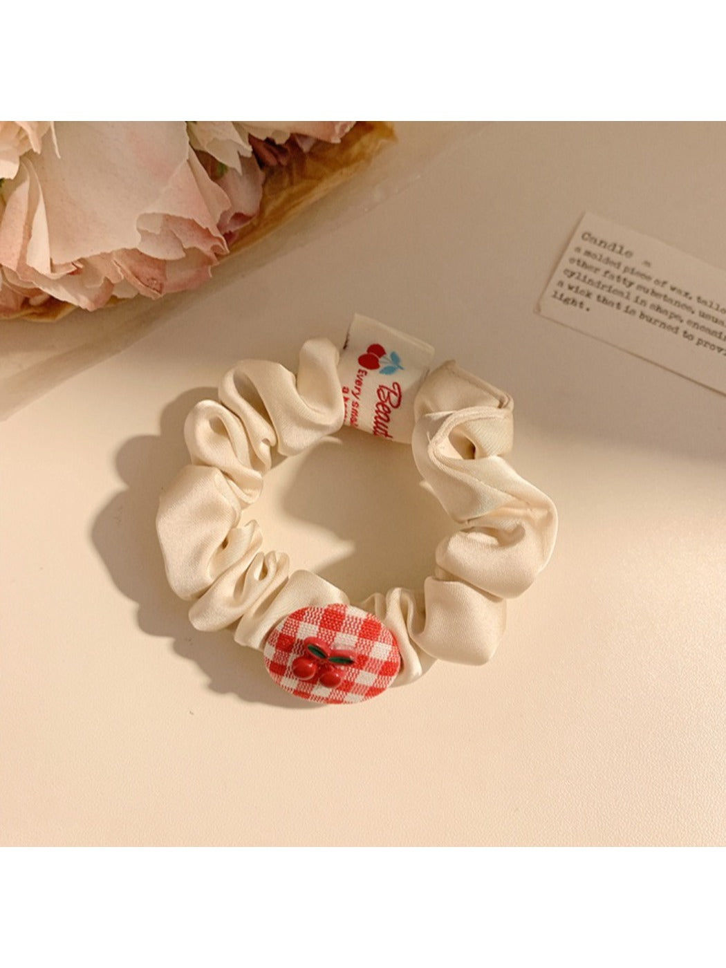 Gifty Sweet Plaid Cherry Hair Tie wrapped around a wrist with cherry charm dangling
