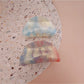 Beau hair clip held in hand displaying size and gradient acrylic material
