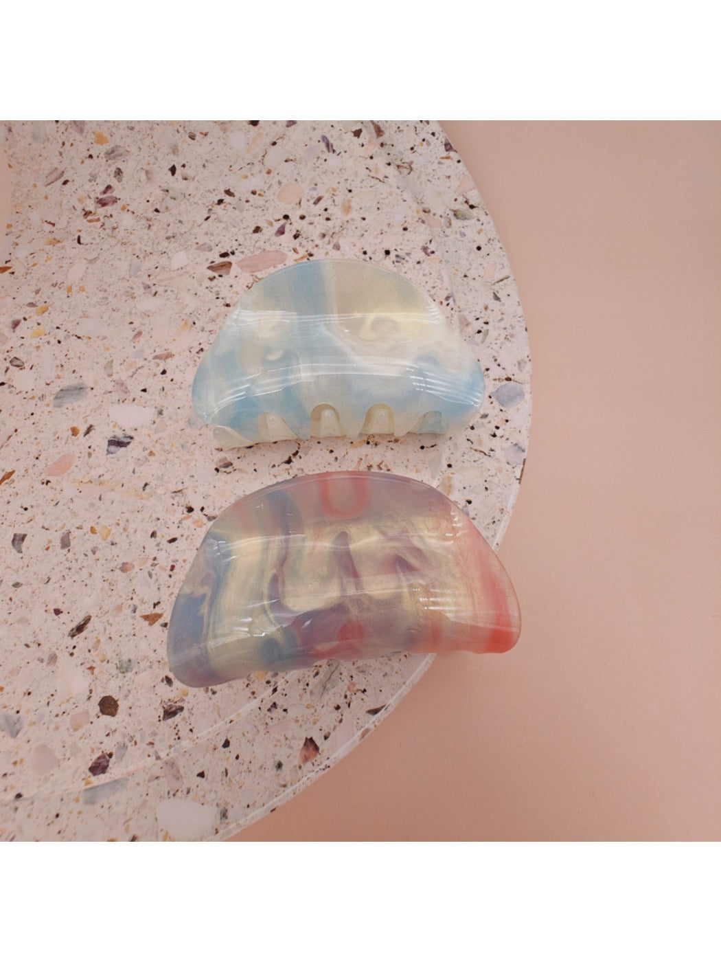 Beau hair clip held in hand displaying size and gradient acrylic material