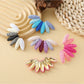 Close-up of Earedge raffia fan earrings showing woven texture and color block design