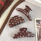 Side view of brown butterfly print claw clip highlighting clasp mechanism