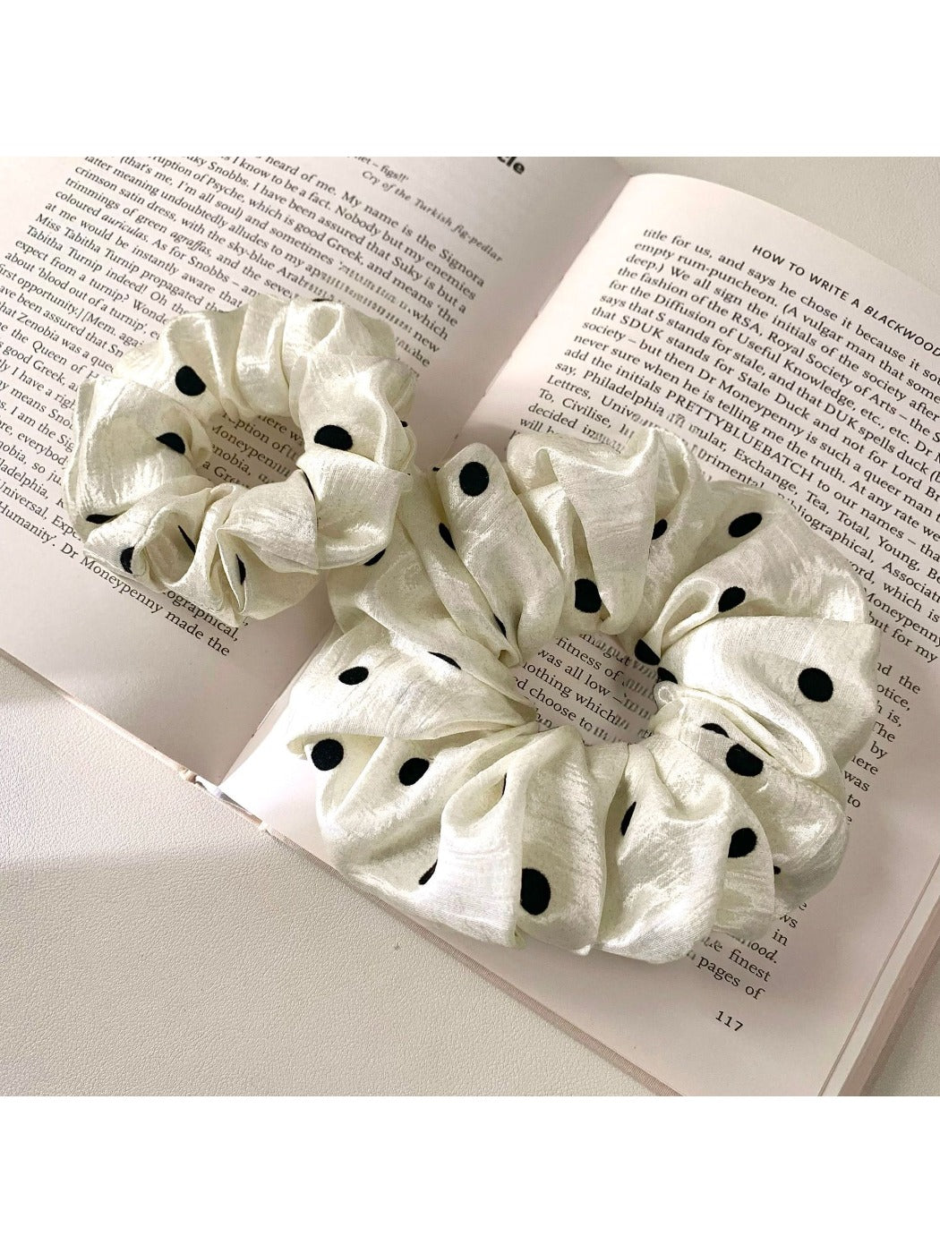 Gifty satin scrunchie with white polka dots displayed on a white surface
