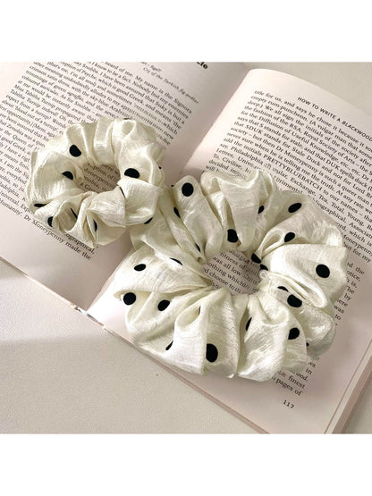 Gifty satin scrunchie with white polka dots displayed on a white surface